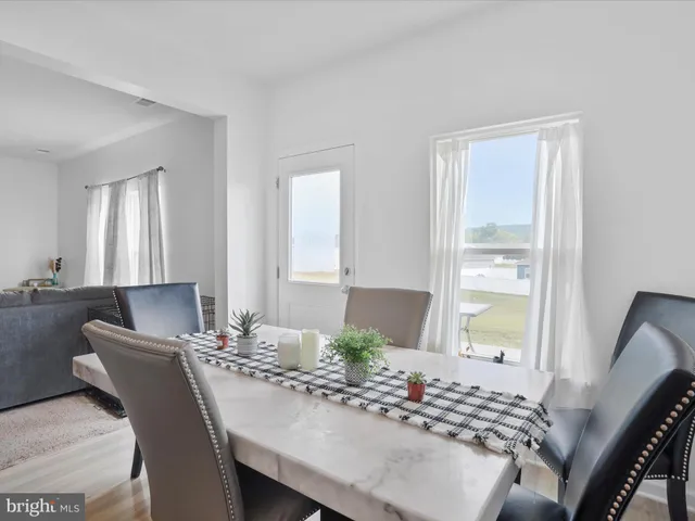 a view of a a dining room with furniture window and wooden floor