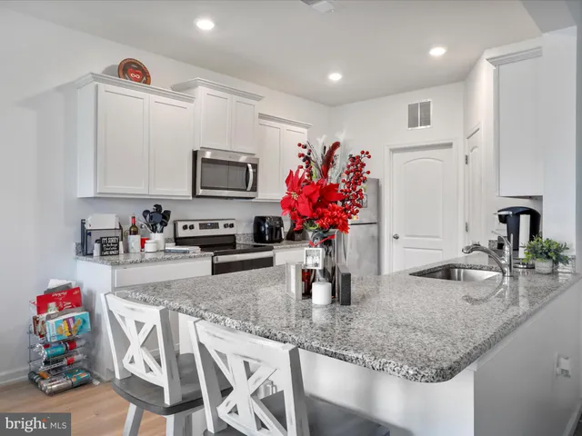a kitchen with granite countertop a sink stove and cabinets
