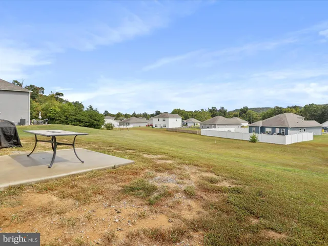 a view of a lake with lawn chairs and iron fence
