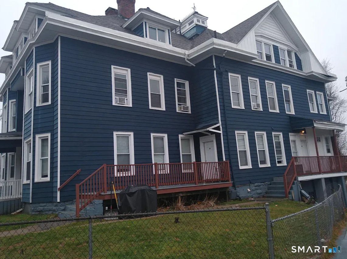 a large brick building with a small yard in front of it