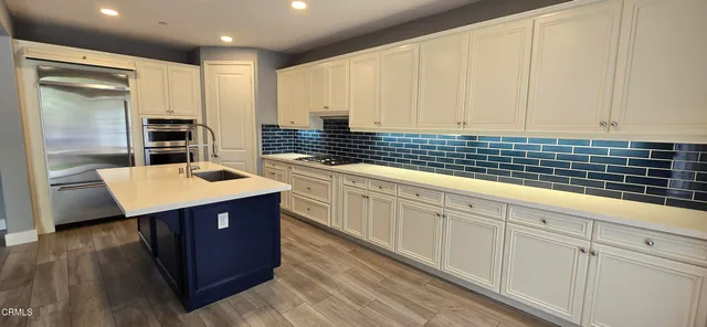a kitchen with stainless steel appliances a sink and cabinets