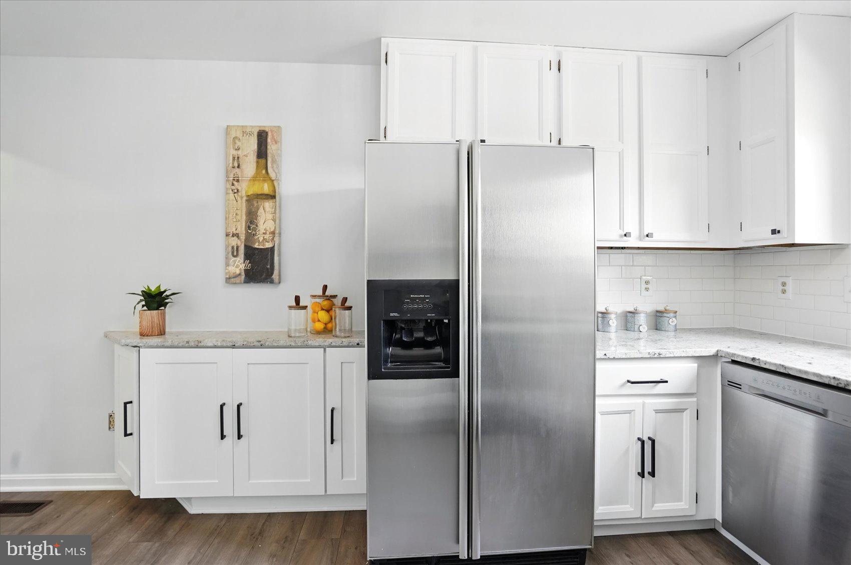 7020 Storch Lane Lanham, MD 20706 - Photo 12 of 44 a kitchen with stainless steel appliances white cabinets and a refrigerator