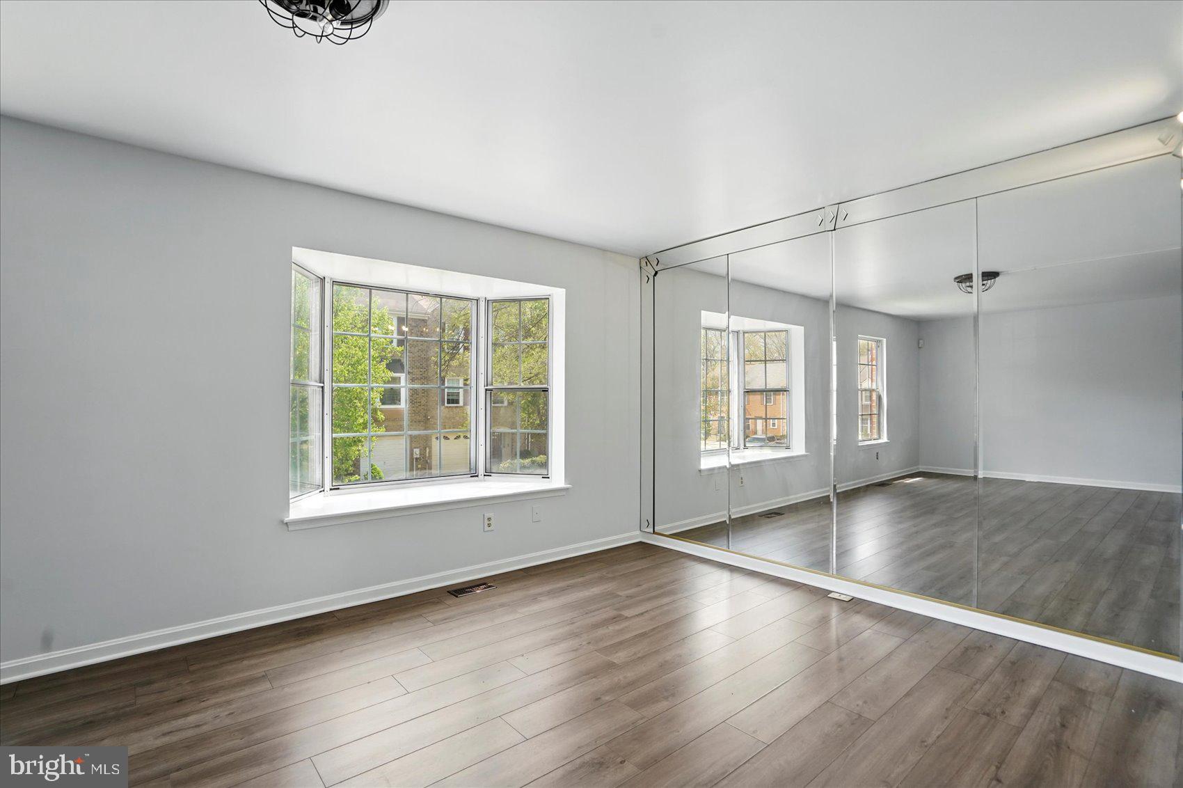 7020 Storch Lane Lanham, MD 20706 - Photo 18 of 44 an empty room with wooden floor and windows