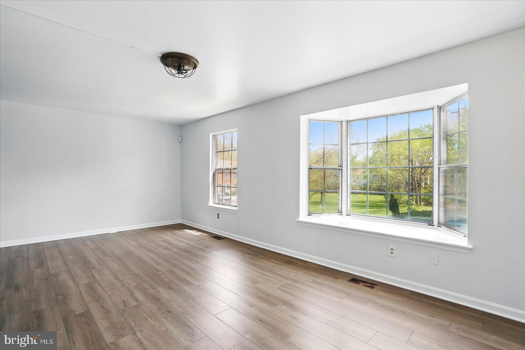 7020 Storch Lane Lanham, MD 20706 - Photo 19 of 44 a view of an empty room with wooden floor and a window