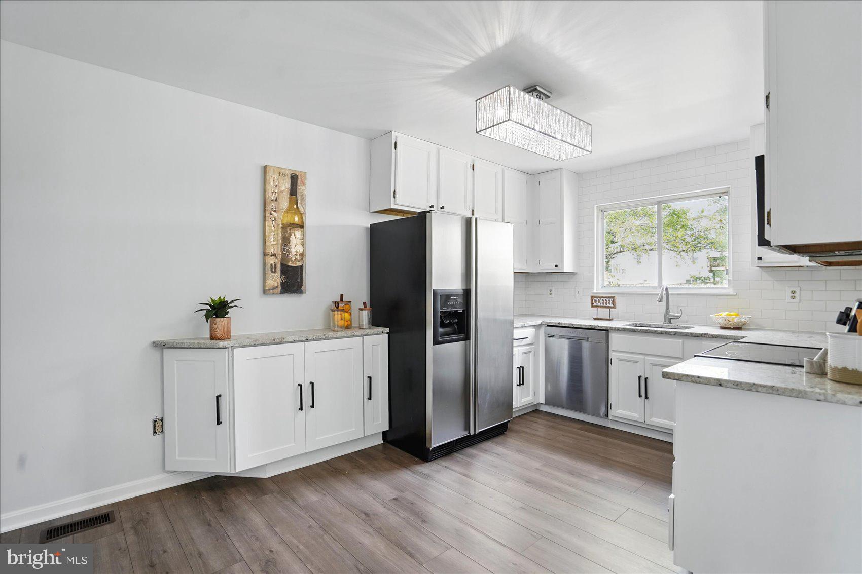 7020 Storch Lane Lanham, MD 20706 - Photo 9 of 44 a kitchen with white cabinets and stainless steel appliances