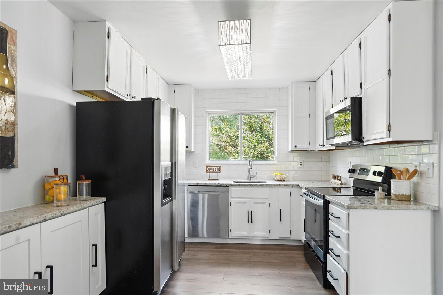 7020 Storch Lane Lanham, MD 20706 - Photo 10 of 44 a kitchen with a sink stove and refrigerator