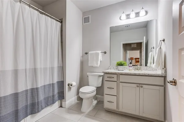 a bathroom with a granite countertop sink a toilet and a mirror