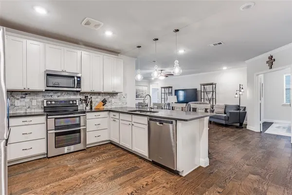 a kitchen with stainless steel appliances kitchen island granite countertop a stove and a sink
