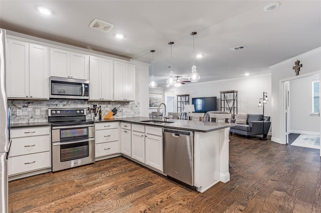 651 Watters Road, Unit 1206 Allen, TX 75013 - Photo 3 of 29 a kitchen with stainless steel appliances kitchen island granite countertop a stove and a sink
