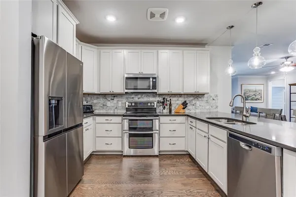 a kitchen with stainless steel appliances granite countertop a refrigerator sink and cabinets