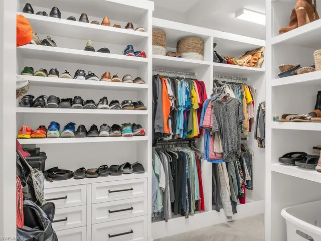 a view of walk in closet with clothes and shoes