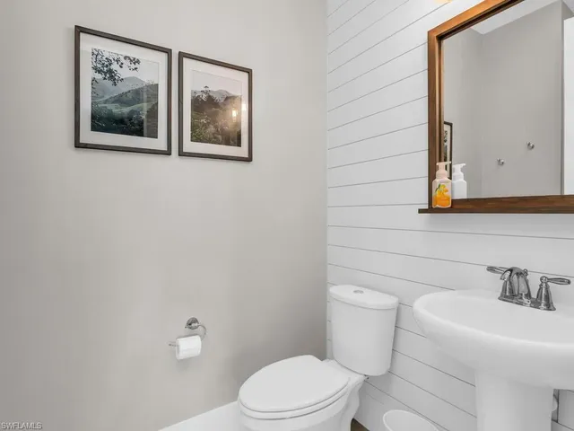 a bathroom with a toilet a sink and mirror