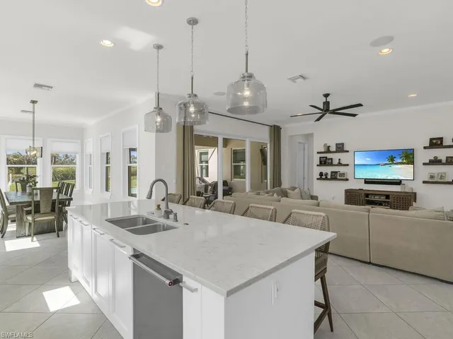 a large kitchen with kitchen island a sink a center island a counter space and a view of living room