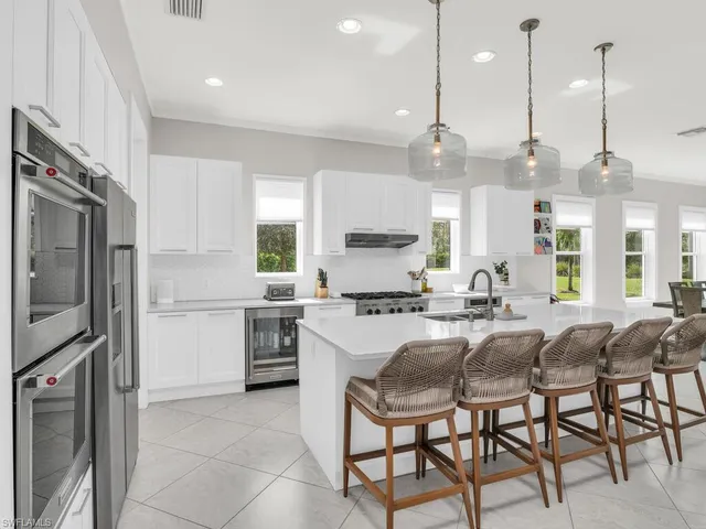a kitchen with appliances cabinets and chairs