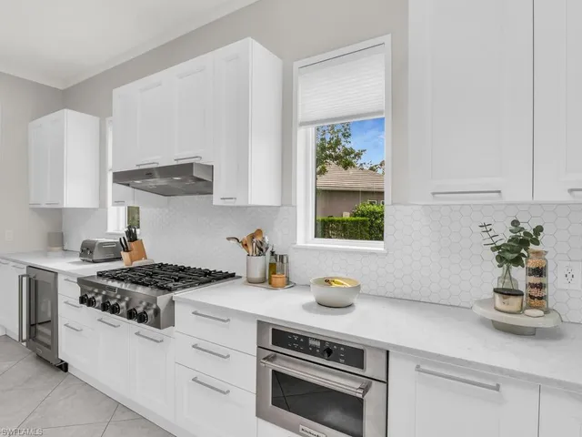 a kitchen with white cabinets and a stove
