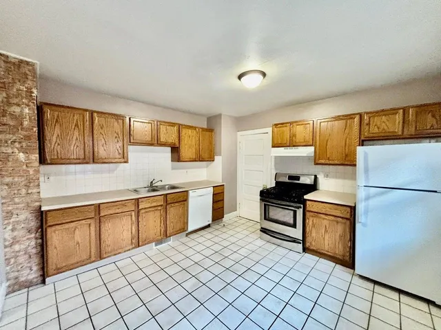 a kitchen with stainless steel appliances granite countertop a stove a sink and a refrigerator