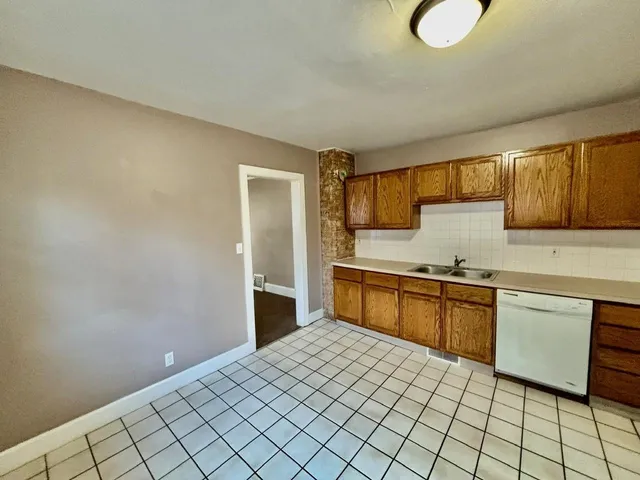 a kitchen with stainless steel appliances granite countertop a sink dishwasher stove top oven and cabinets