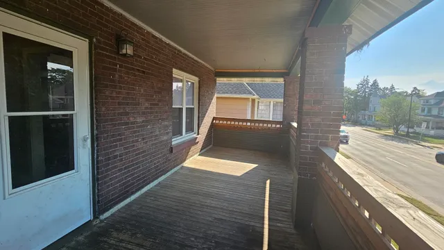a view of a balcony with wooden floor and bench