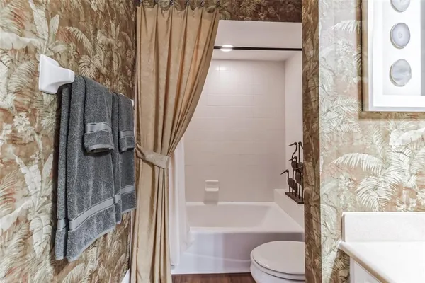 a bedroom with a large bed and a flat tv screen on dresser