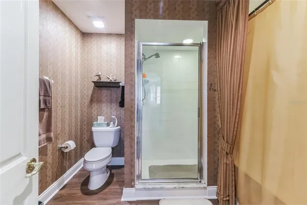 a spacious bedroom with a bed a couch and a chandelier