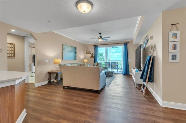 a living room with furniture large window and wooden floor