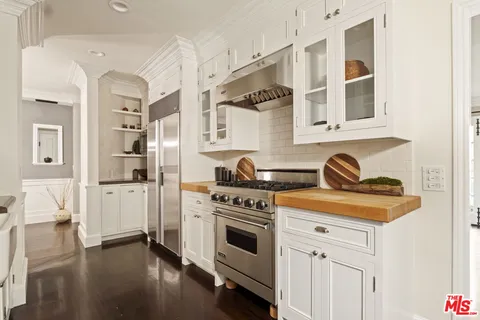 a kitchen with stainless steel appliances granite countertop a stove and white cabinets
