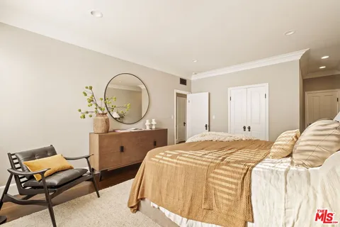 a bed room with a bed a chair and a potted plant