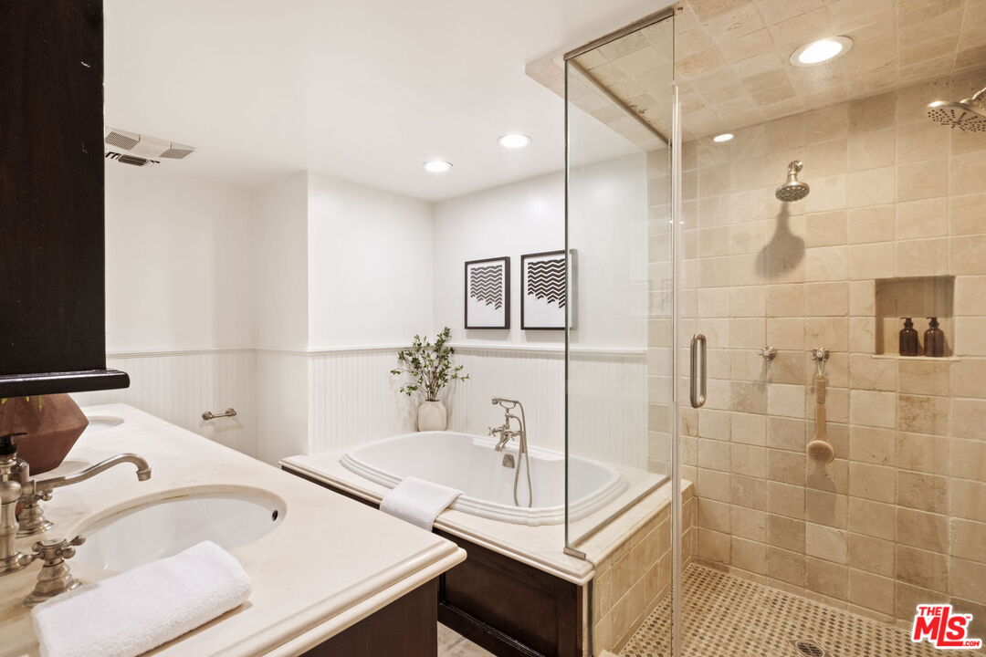 8455 Fountain Avenue, Unit 411 West Hollywood, CA 90069 - Photo 18 of 27 a bathroom with a tub sink vanity and mirror