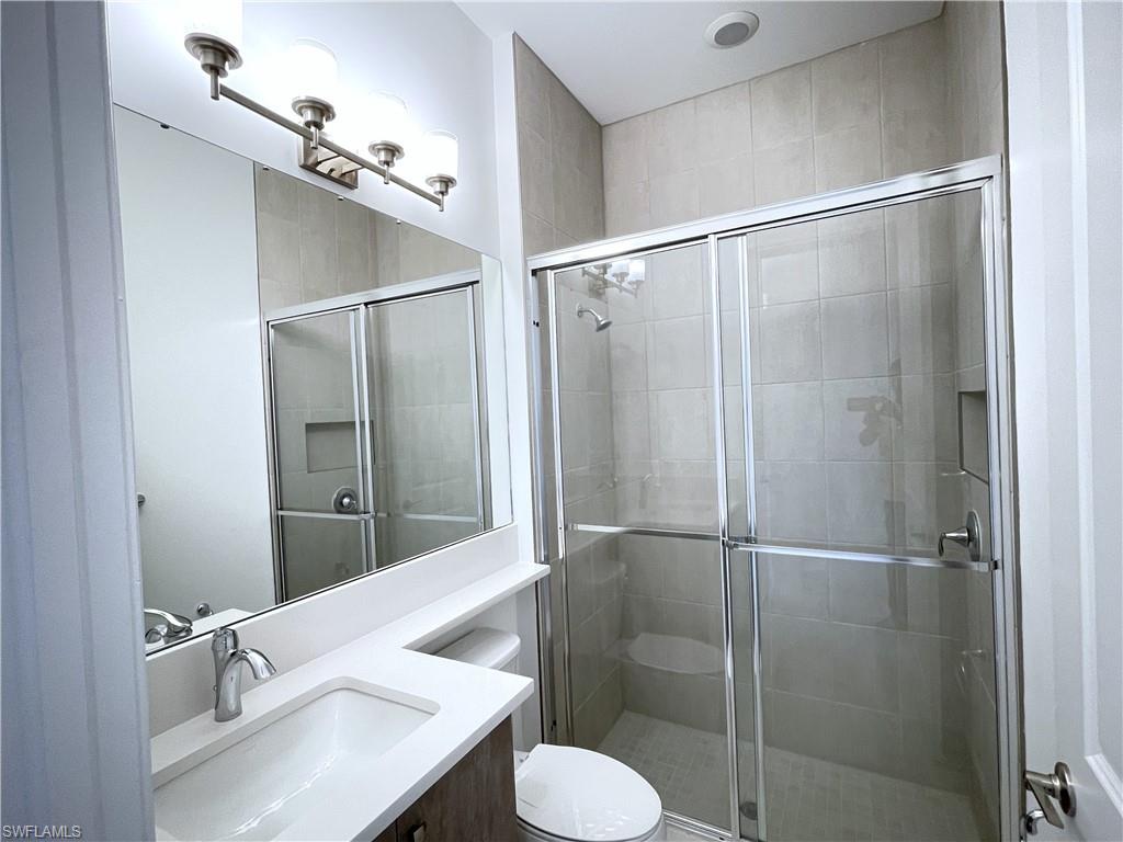 20909 Thistle Leaf Lane Estero, FL 33928 - Photo 9 of 18 a bathroom with a sink toilet and shower