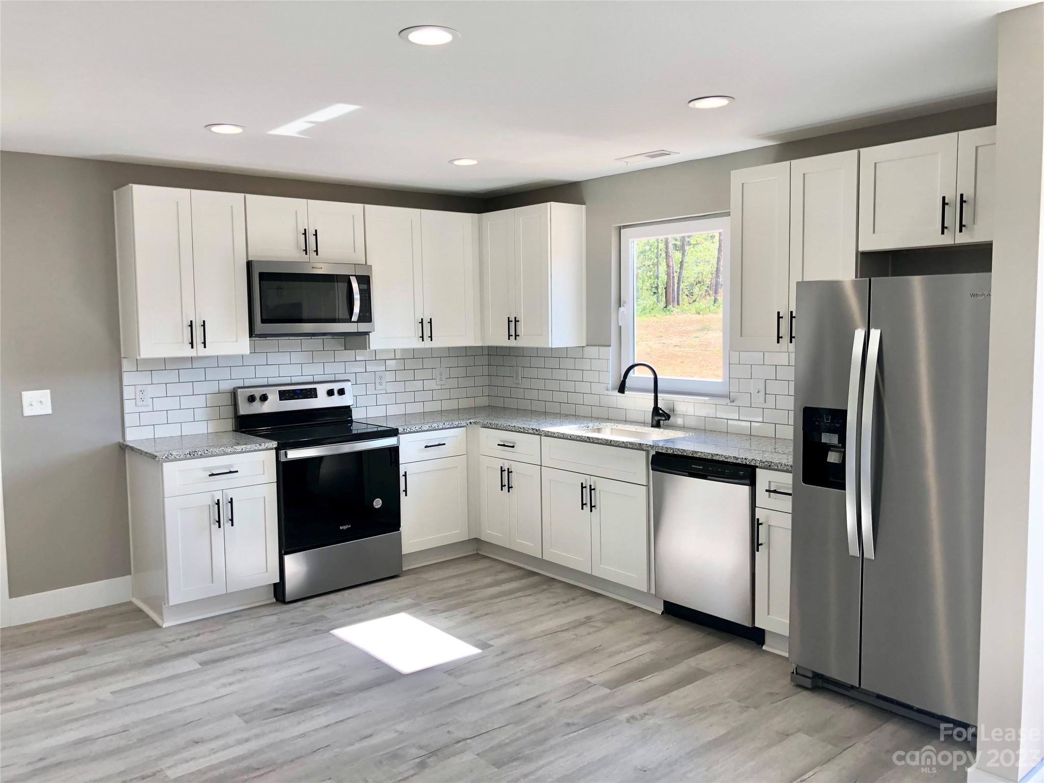 2435 Laboratory Road Lincolnton, NC 28092 - Photo 2 of 19 a kitchen with stainless steel appliances granite countertop a refrigerator stove a sink and a microwave