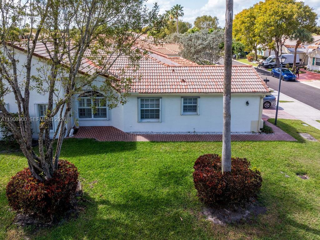6050 Heliconia Road, Unit 6050 Delray Beach, FL 33484 - Photo 2 of 29 a view of a backyard with potted plants and large trees