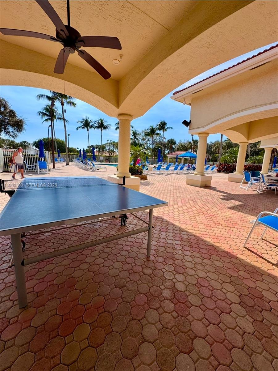 6050 Heliconia Road, Unit 6050 Delray Beach, FL 33484 - Photo 29 of 29 a view of a patio with a table and chairs under an umbrella