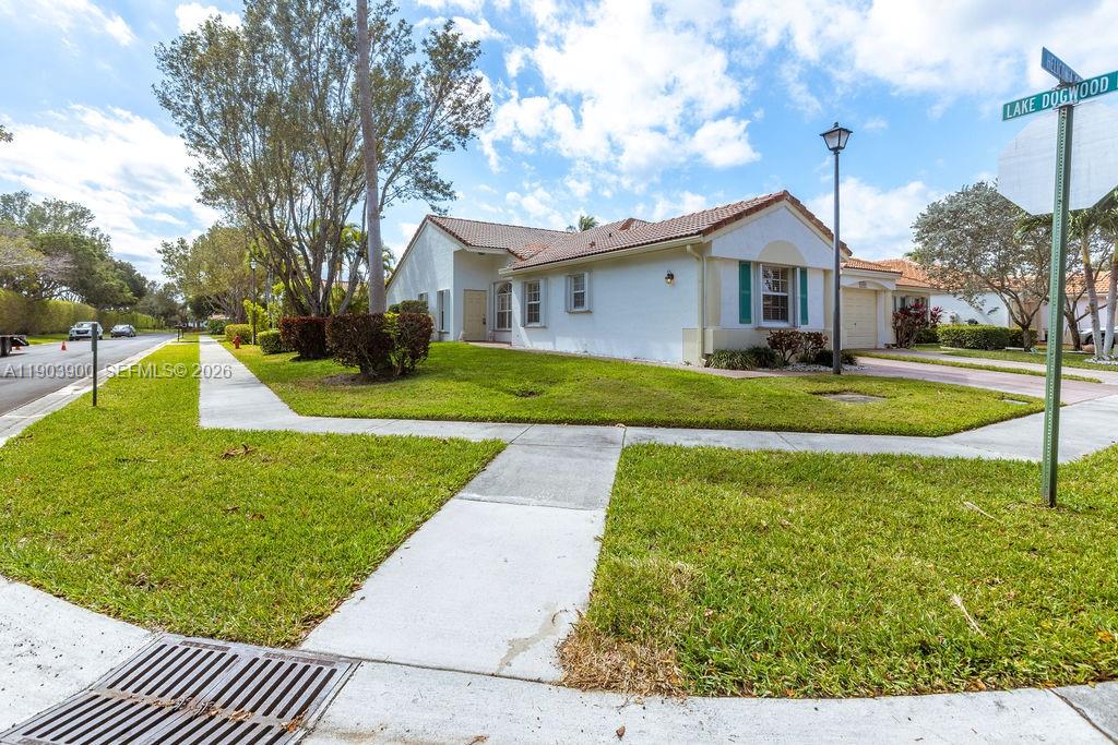 6050 Heliconia Road, Unit 6050 Delray Beach, FL 33484 - Photo 3 of 29 a front view of a house with a yard