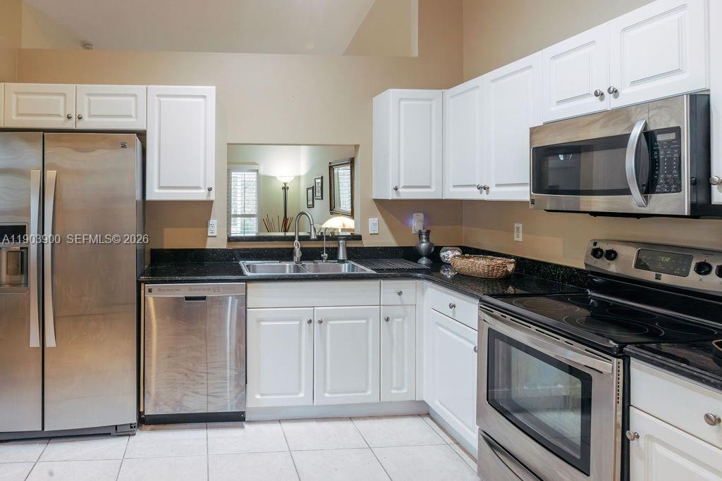 6050 Heliconia Road, Unit 6050 Delray Beach, FL 33484 - Photo 8 of 29 a kitchen with cabinets stainless steel appliances and a sink