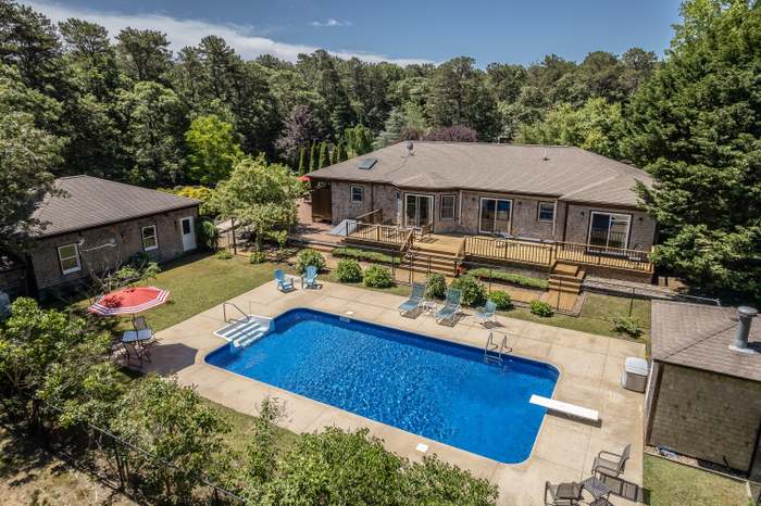 a view of a house with pool and chairs