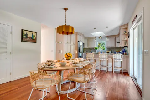 a dining room with furniture a chandelier and wooden floor
