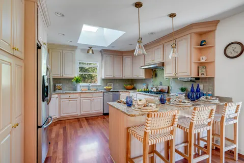 a kitchen with stainless steel appliances kitchen island granite countertop a stove a sink and a refrigerator