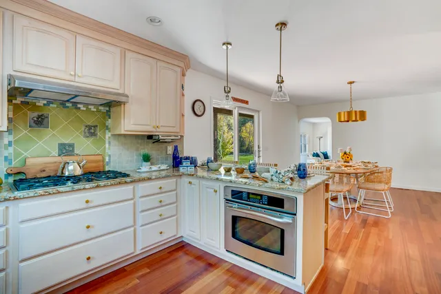 a kitchen with stainless steel appliances granite countertop a stove and a wooden floors