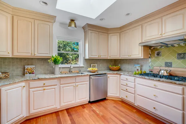 a kitchen with granite countertop white cabinets and white appliances