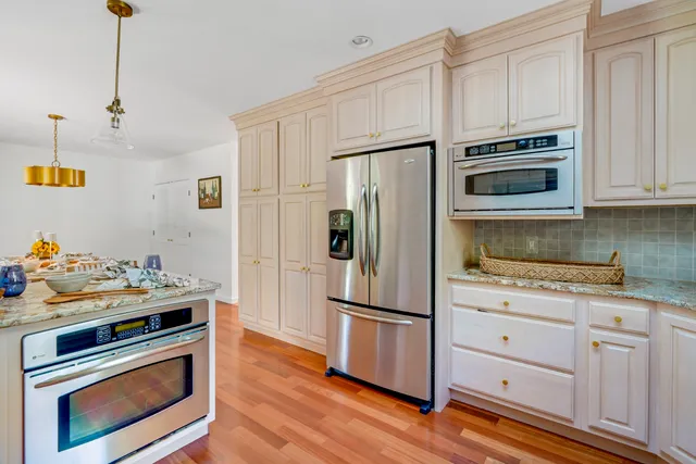 a kitchen with granite countertop wooden cabinets and stainless steel appliances