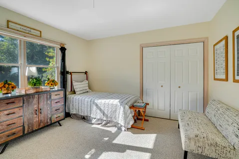 a bedroom with a bed and large windows