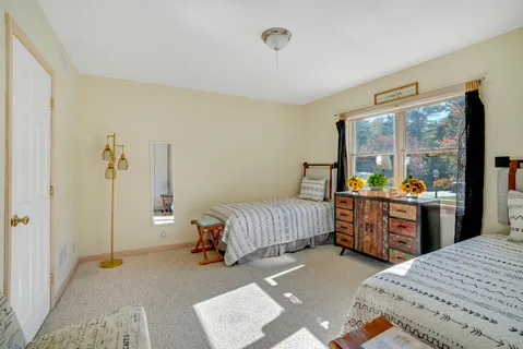 a bedroom with a bed and a dresser next to a window