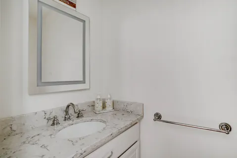 a bathroom with a granite countertop sink and a mirror