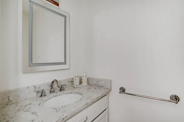 a bathroom with a granite countertop sink and a mirror