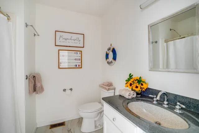 a bathroom with a sink mirror vanity and toilet