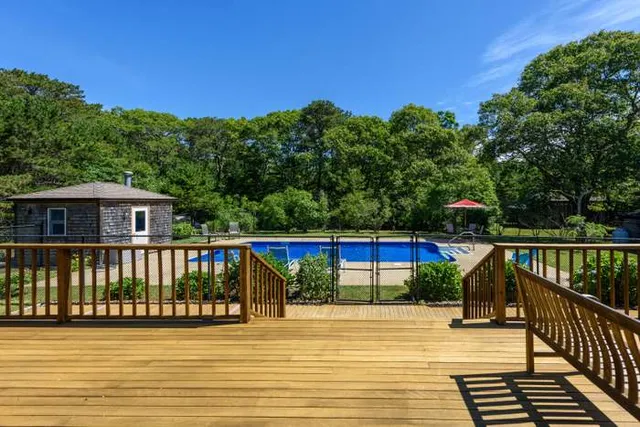 a view of a balcony with wooden floor and fence