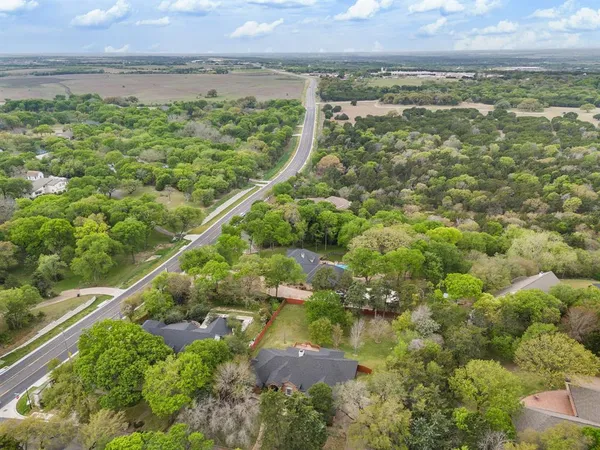 an aerial view of residential houses with outdoor space and trees