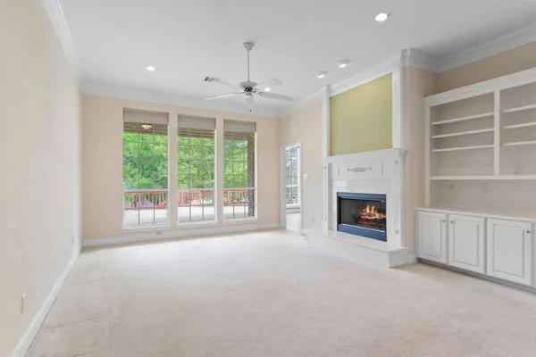 a view of an empty room with a fireplace and a window