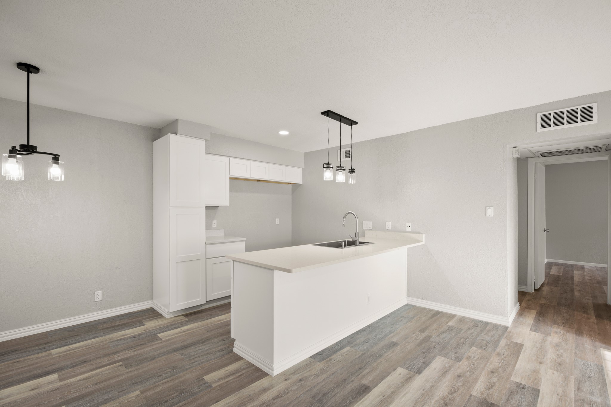 910 Duncan Lane, Unit 56 Austin, TX 78705 - Photo 5 of 17 a view of a kitchen with a sink and wooden floor