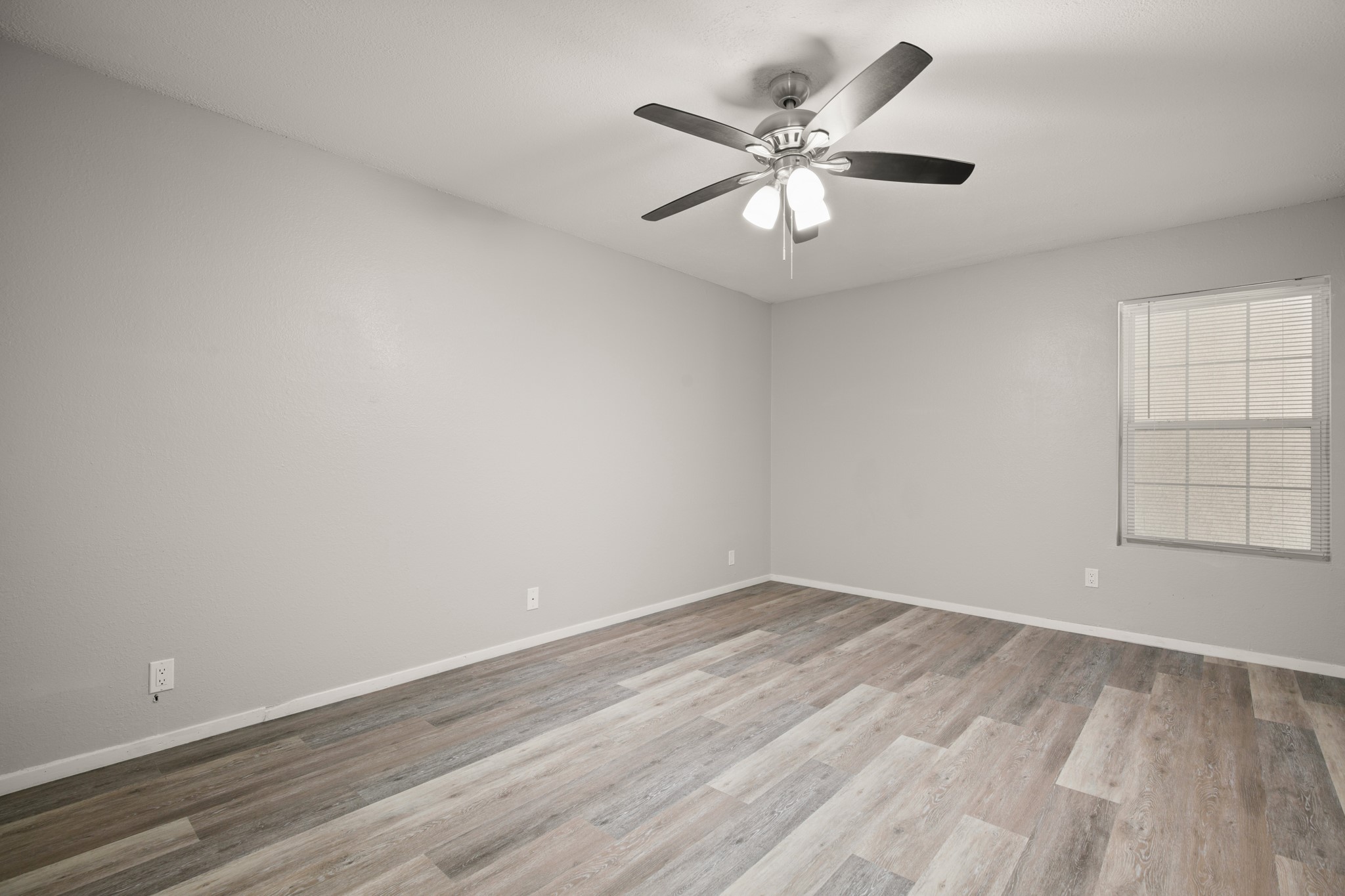 910 Duncan Lane, Unit 56 Austin, TX 78705 - Photo 9 of 17 an empty room with wooden floor and windows